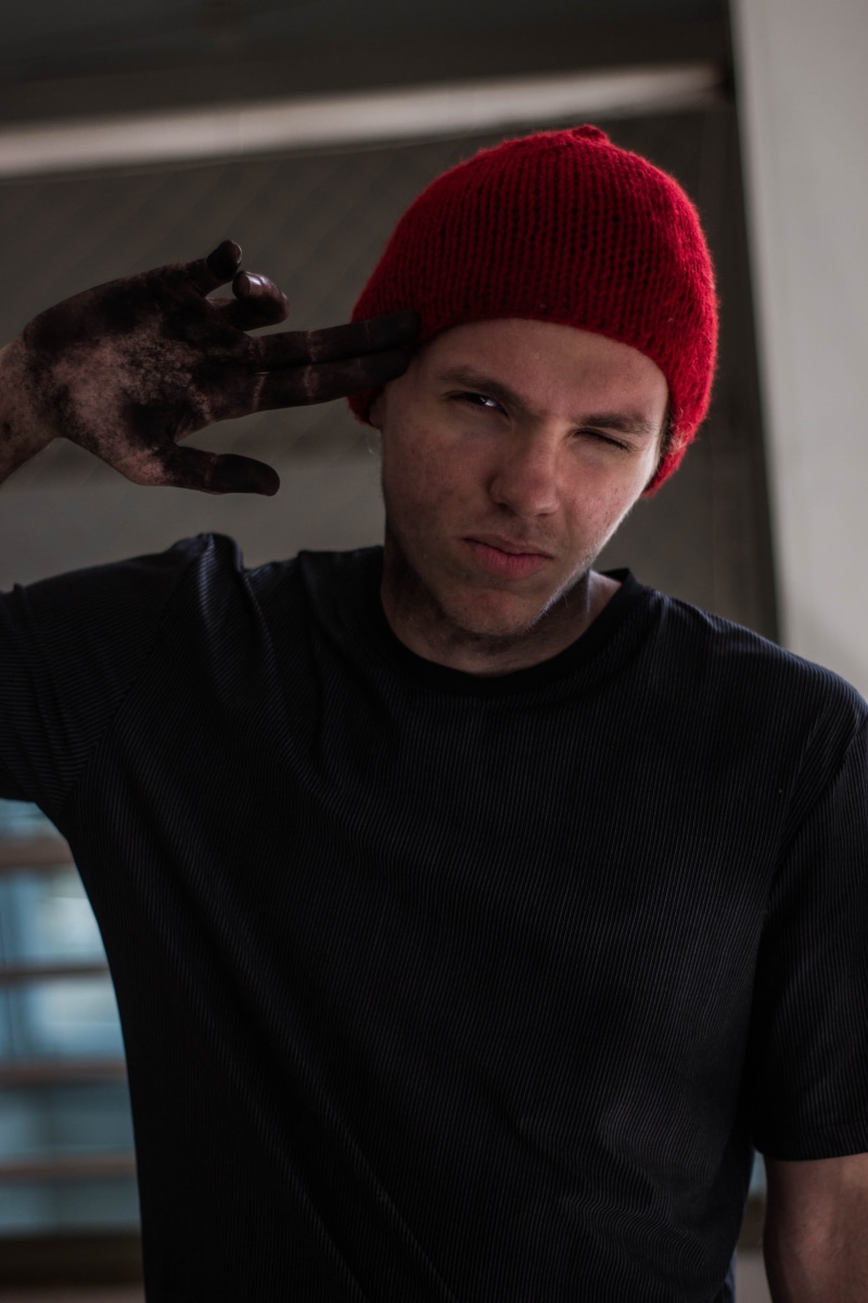 twenty one pilot, cap, cosplay, eye closed, pointing, man, clothing, holding, top, knit hat, indoors, front view, waist up, gun, t, beanie, crew, band