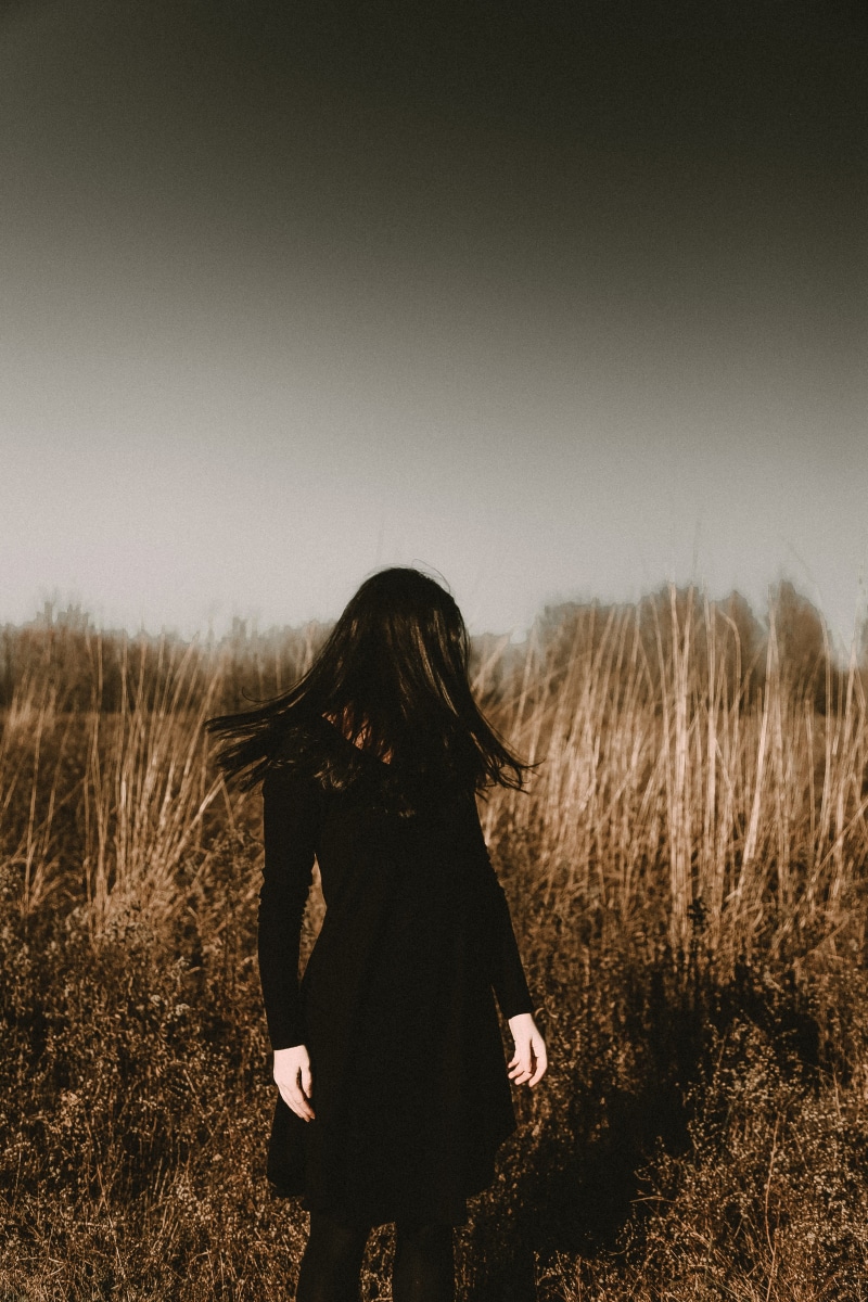outdoors, woman, casual clothing, brunette, field, black, nature, hair, human, clear sky, hidden face, women, long hair, hairstyle, dress, portrait, clothing