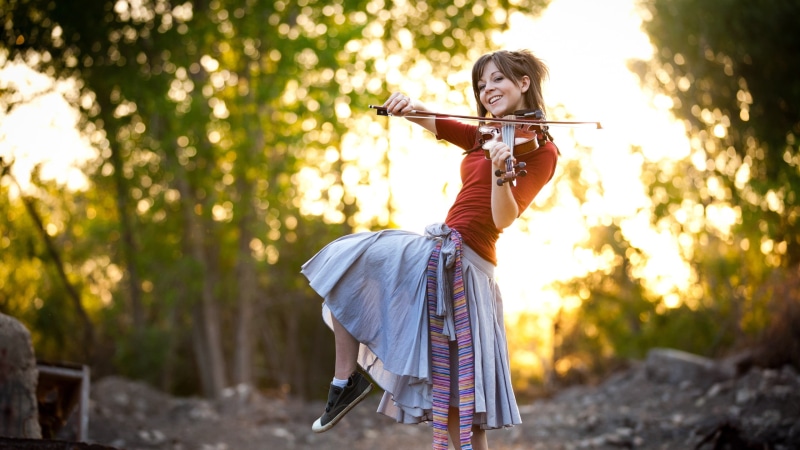 adult, women outdoors, real people, musical instrument, outdoors, smiling, motion, forest, woodland, young adult, weapon, sunlight, nature, celebrity, hairstyle