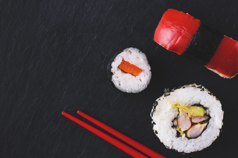 rice - food staple, black background, sushi, plate, food, indoors, no people, chopsticks, rice, directly above, seafood, healthy eating, asian, fish, food and Drink