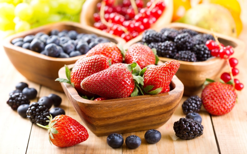 focus on foreground, wooden surface, table, berry fruit, no people, wellbeing, ripe, healthy eating, strawberries, red currant, blueberries, bowl, lunch