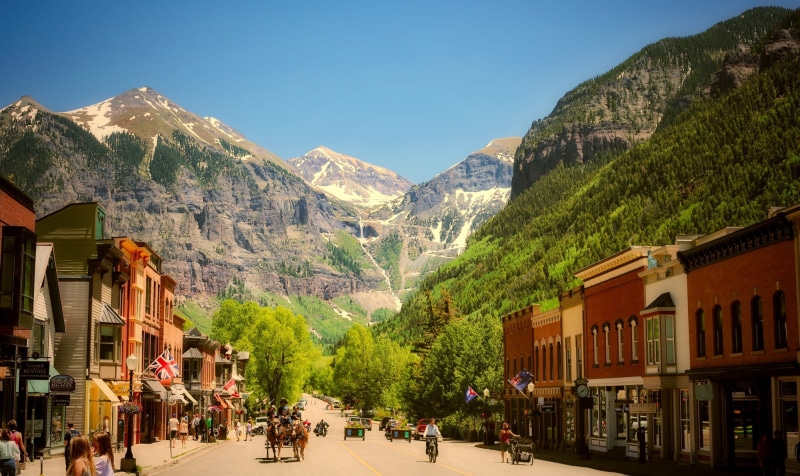 bicycle, mountain range, person, telluride, city, cold temperature, outdoors, riding, mountain peak, travel destinations, clear sky, snowcapped mountain
