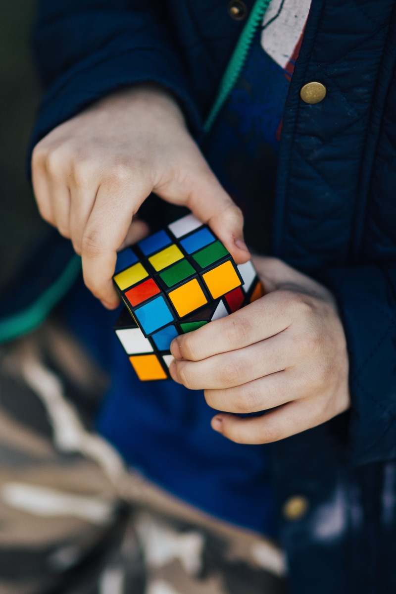 human limb, rubiks cube, human Hand, finger, midsection, leisure activity, real people, multi colored, body part, adult, standing, adults only, casual clothing