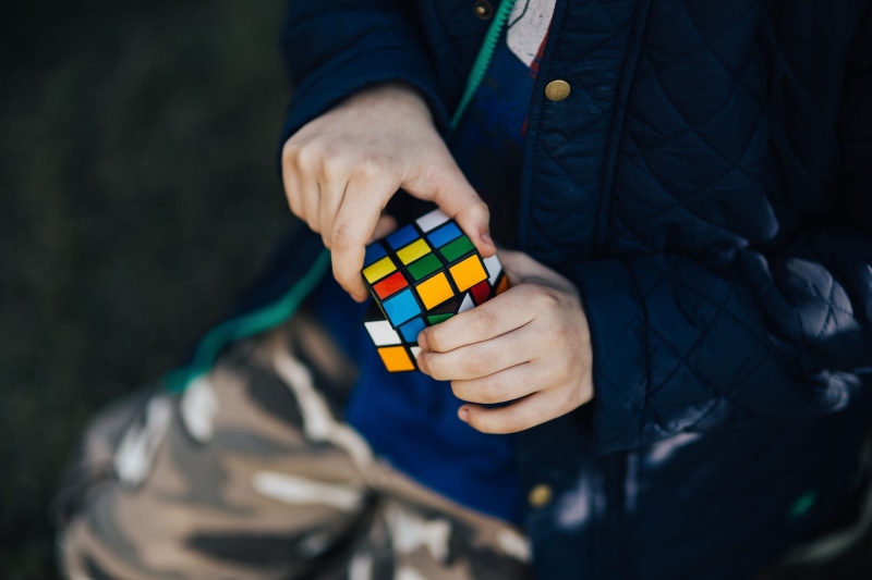 midsection, clothing, adults only, human body part, one Person, Boy, blue jacket, childhood, front view, real people, leisure Games, rubiks cube, focus on foreground
