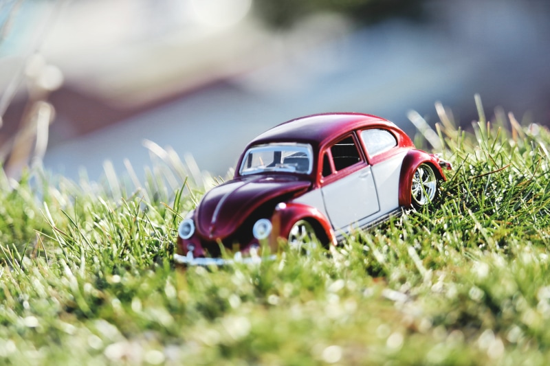 motor vehicle, color, plant, coupe, silver colored, selective focus, toy car, summer, chrome, mode of transportation, old, scale, parking car, model, oldtimer