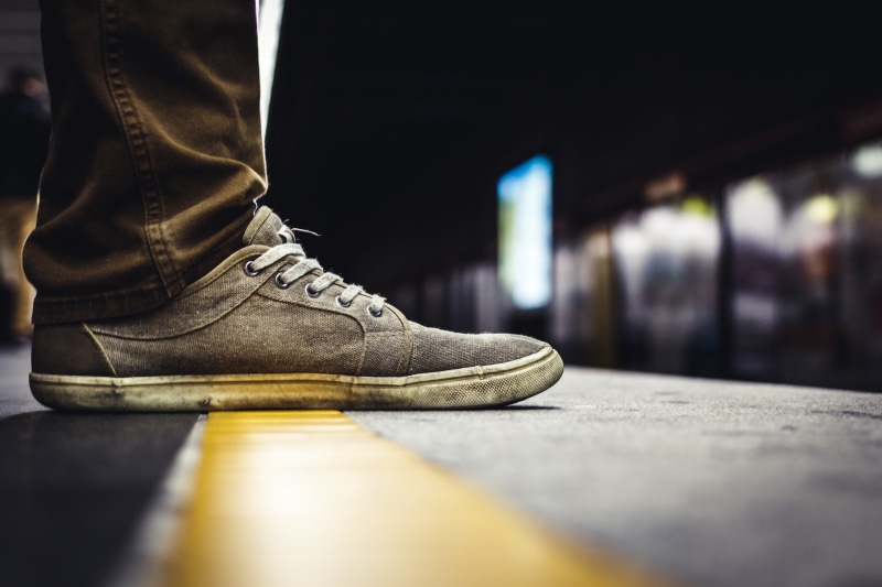 relaxation, surface level, black, person, adult, leather, transportation, concrete, sneakers, selective, low section, one person, wearing, metro, human limb