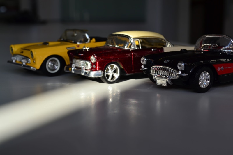 toy, plastic, cast, car, red, indoors, black, mode of transportation, models, racecar, land vehicle, Toys, selective focus, table, close-up, no people