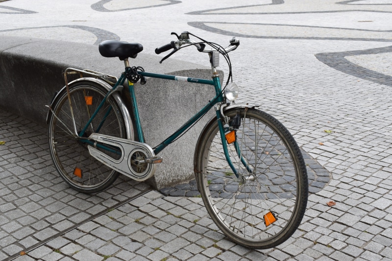 land vehicle, high angle view, green, parking, bicycle basket, saddle, day, cobblestone, bike, vintage, transport, bicycle, wall, spoke, cycling, wheel