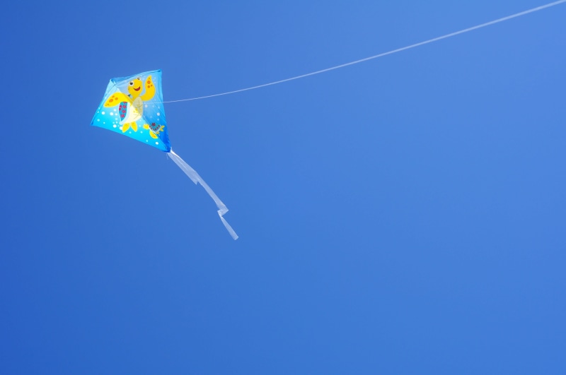 flag, wind, no people, blue, play, day, mid-air, kite, clear sky, nature, air vehicle, copy space, vapor trail, kids, outside, freedom, outdoors, motion