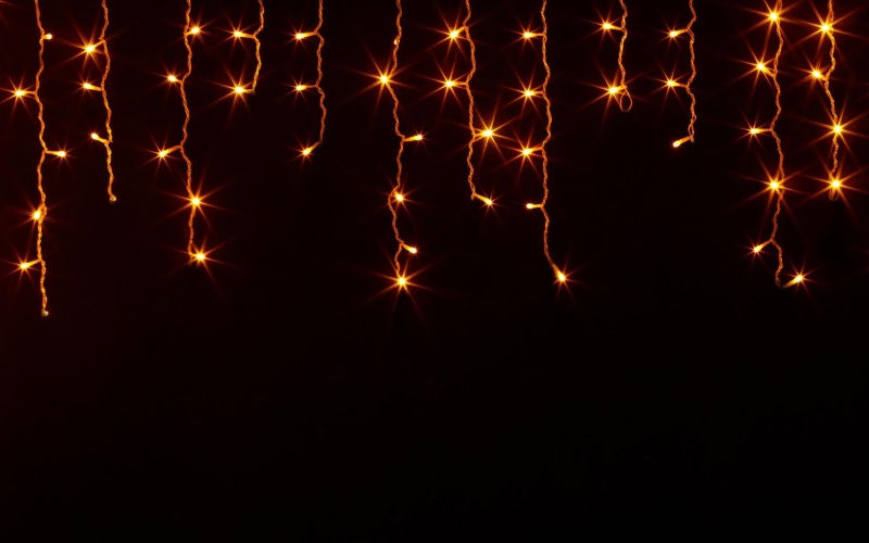 black background, no people, lighting equipment, large group of objects, copy space, light, pattern, celebration, in a row, 2K, string, dark, shape, orange color