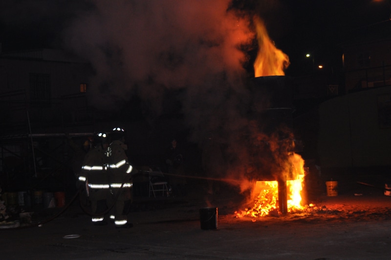 sign, building exterior, people, molten, smoke - physical structure, foundry, nature, outdoors, metal, firefighter, metallurgy, fire - natural phenomenon