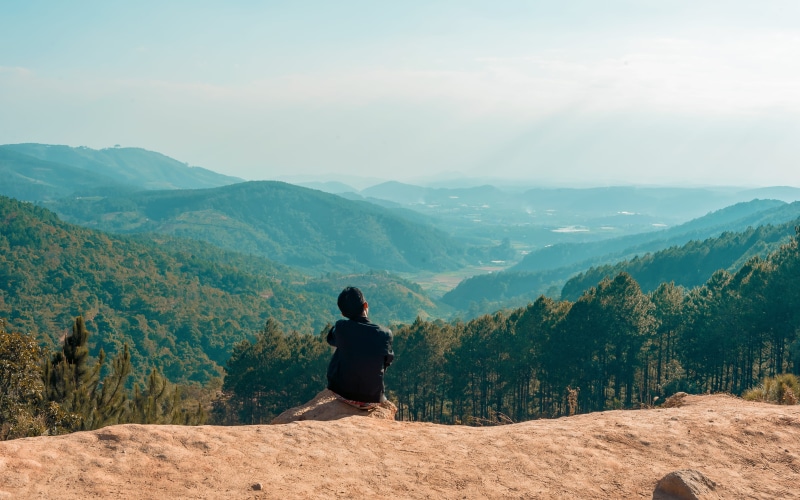 non-urban scene, one person, tranquility, daylight, tranquil scene, scenic, edge, scenics - nature, mountain range, sky, high, trip, beauty in nature, real people