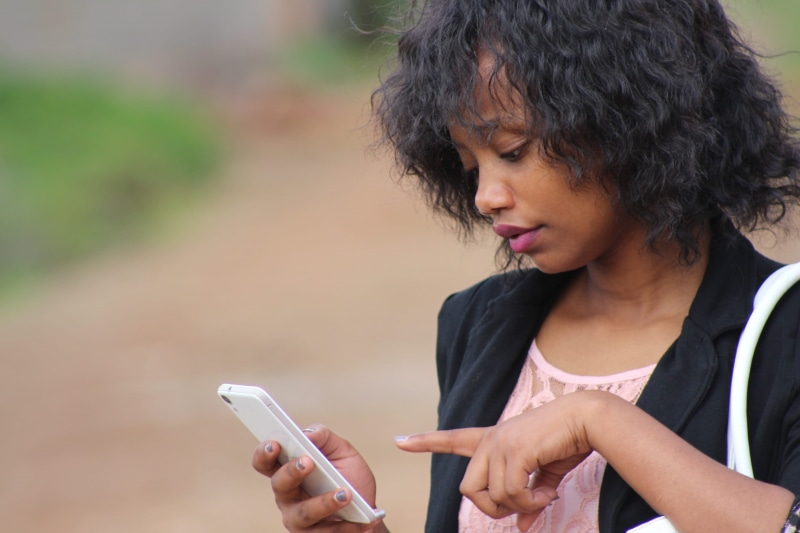 confused, females, lady, real people, coat, text Messaging, afro, business, black haired, portrait, leisure activity, african, smartphone, young, confused woman