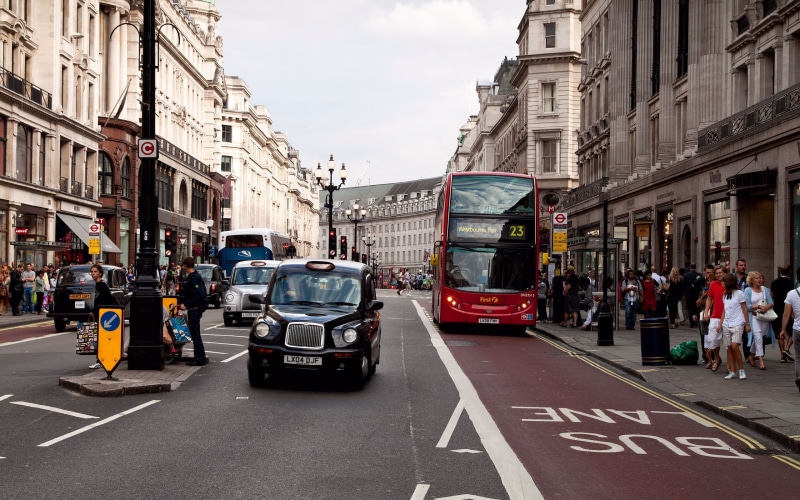 real people, outdoors, city street, sign, built Structure, cityscape, england, mode of transportation, building Exterior, city Life, capital Cities, double-Decker Bus