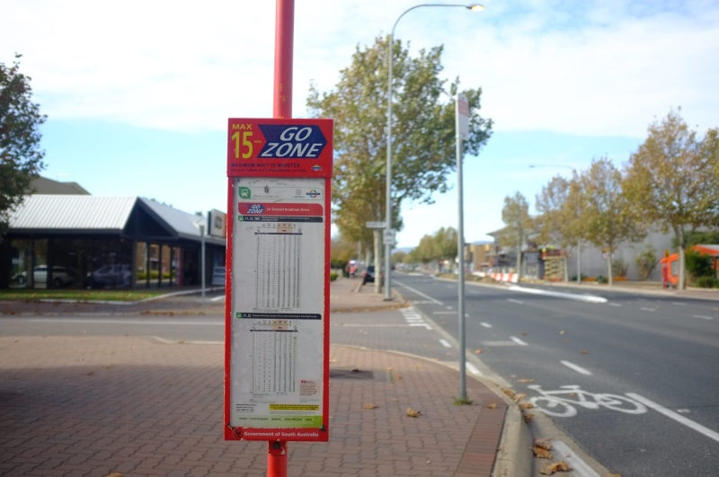 text, guidance, building exterior, australia, south australia, bus stop, outdoors, city, 4K, tree, symbol, road, road marking, built structure, downtown
