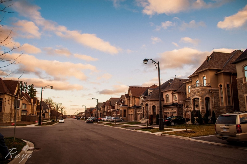 car, motor vehicle, land vehicle, residential district, direction, building exterior, neighborhood, raod, city, clouds, transportation, architecture, sky