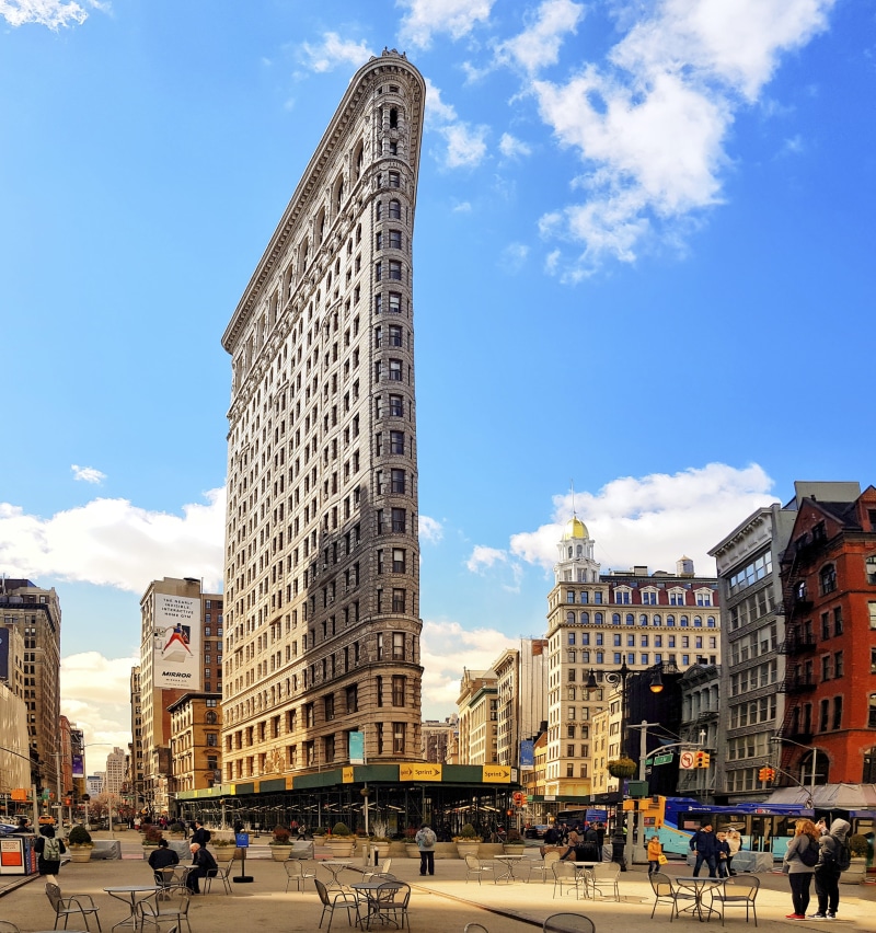 motor vehicle, flat iron, urban, road, town square, plaza, metropolis, outdoors, car, city, office building exterior, mode of transportation, land vehicle