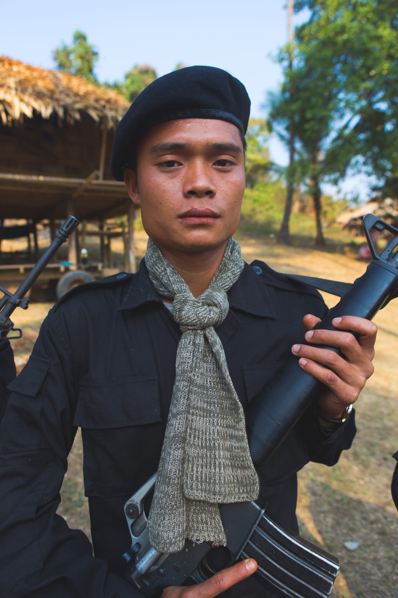 standing, looking at camera, myanmar (burma), rifle, burma, asia, outdoors, myanmar, clothing, young adult, nature, day, hat, people, culture, three quarter length