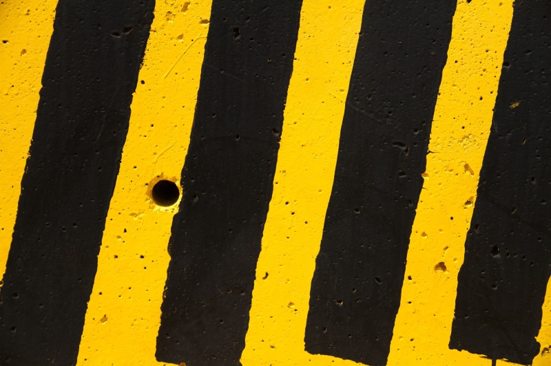 high angle view, day, yellow, crosswalk, hole, wall, stripes, communication, black, symbol, road, marking, guidance, transportation, dividing line, black color