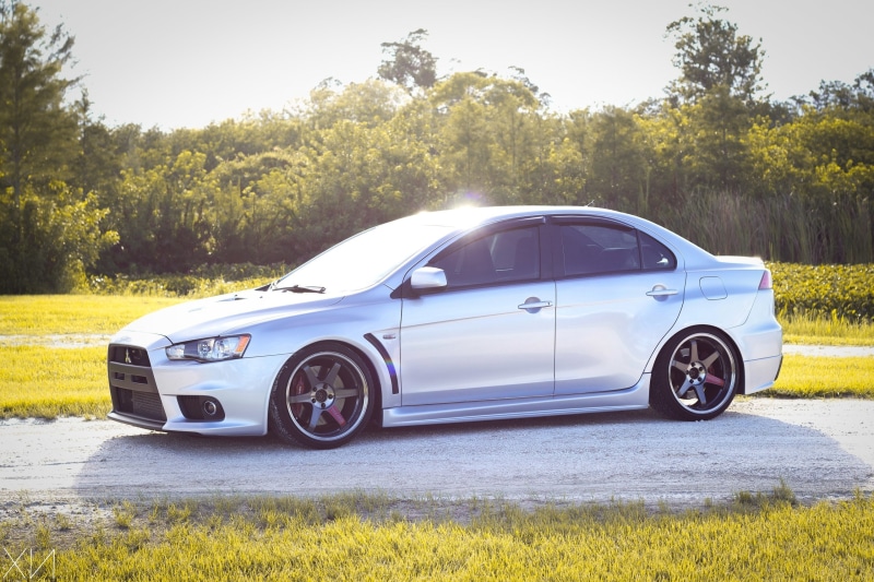 wheels, 2K, motor vehicle, field, land, lancer, grass, jdm, evo x, no people, sunlight, mode of transportation, green color, stationary, land vehicle
