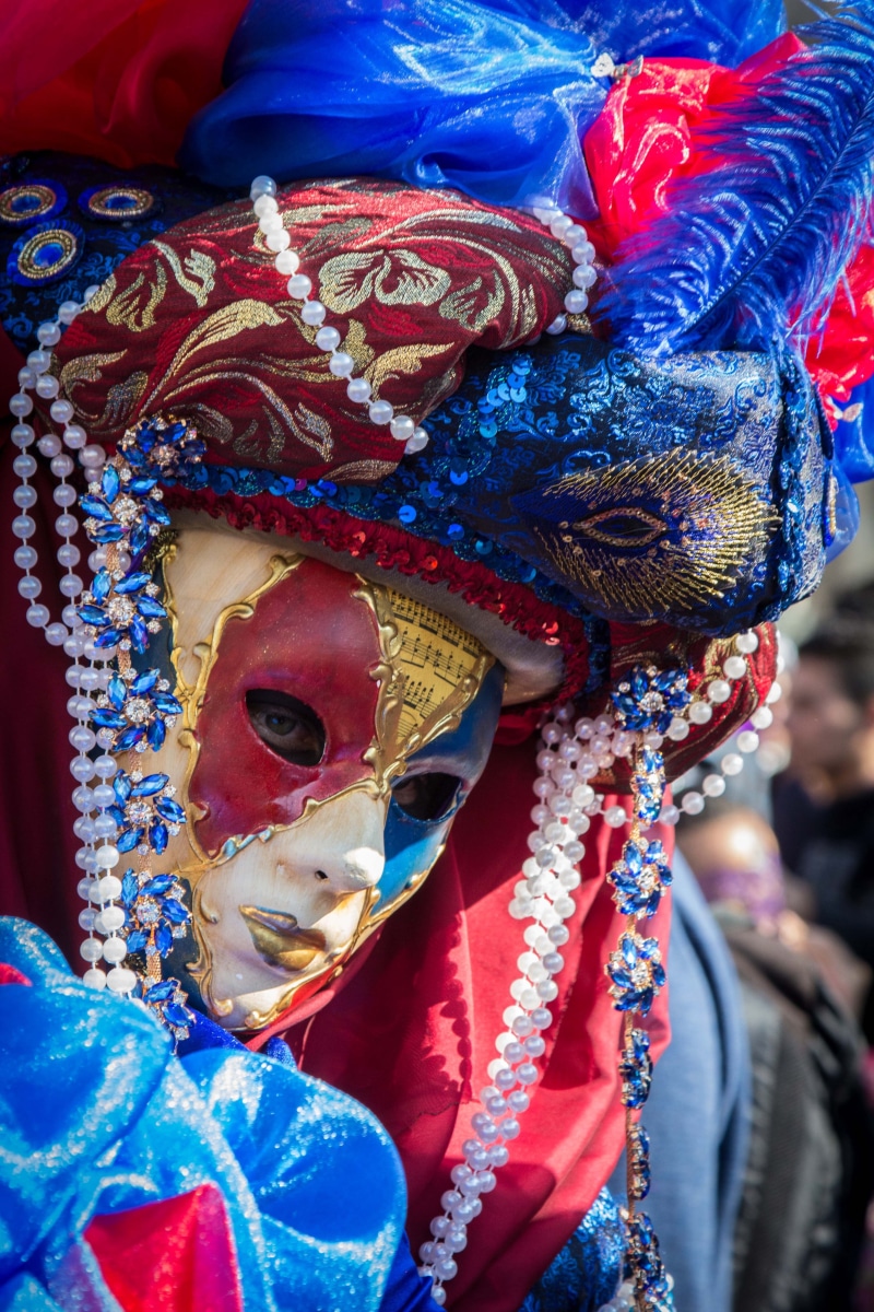 wearing, arts culture and entertainment, traditional clothing, outdoors, carnival, face, carnival - celebration event, white, real people, mystery, venetian