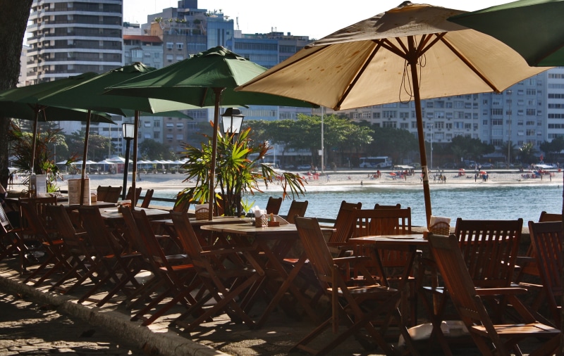water, parasol, lot, built structure, seat, brown, walk, no people, cafe, day, breakfast, absence, patio, green, plant, swimming pool, building exterior