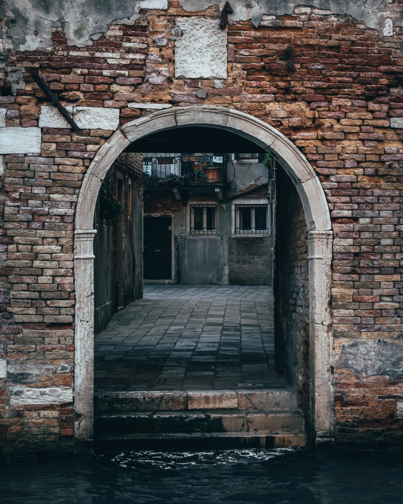 slate, flagstone, patio, arched, entrance, stone wall, day, building exterior, canal, sidewalk, arch, crypt, building, torii, corridor, brick wall, door
