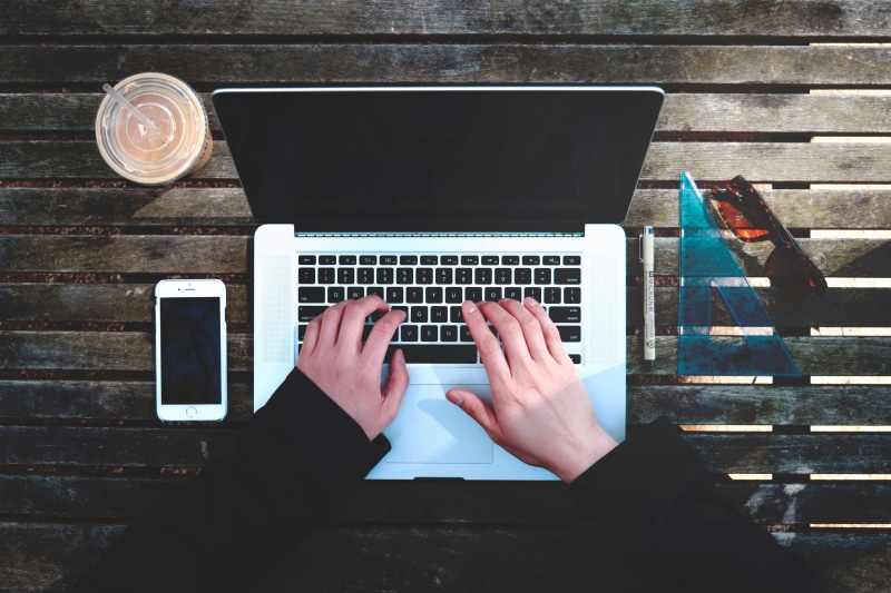 connection, drink, human body part, macbook, laptop, browser, leisure activity, portable information device, typing, finger, one person, table, wireless technology