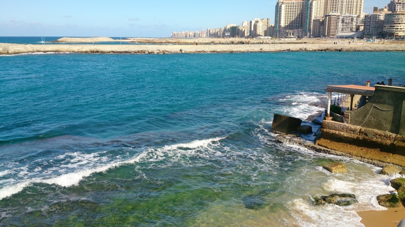 office building exterior, built structure, outdoors, architecture, beauty in nature, aquatic sport, Mediterranean, beach, Egypt, day, motion, shoreline