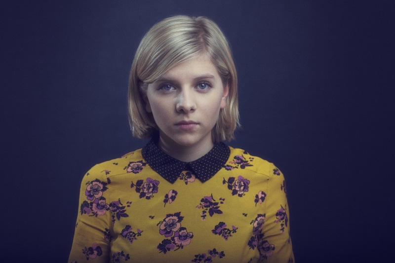 beautiful woman, front view, portrait, blond hair, innocence, looking at camera, one person, studio shot, hairstyle, women, black background, headshot