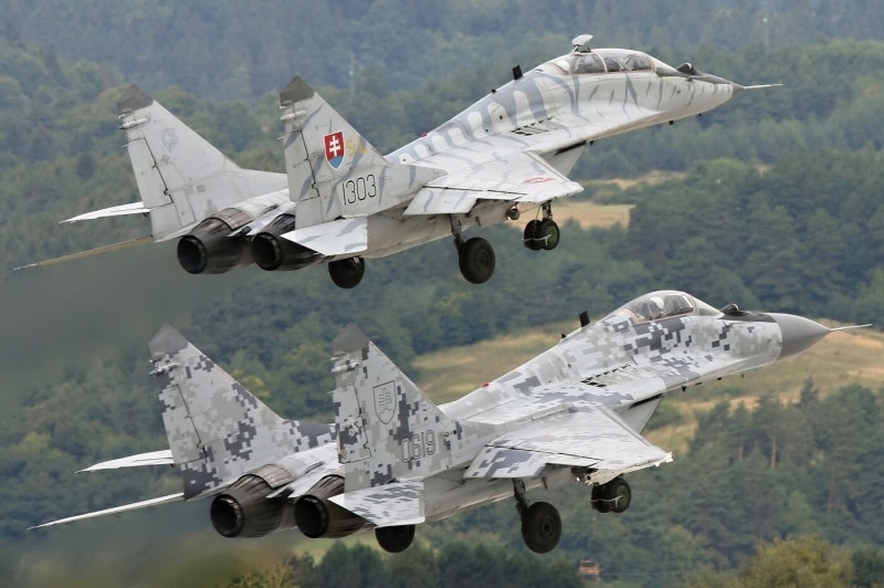 side view, camouflage, navy, jets, 720P, mig-29, air vehicle, plane, mid-air, outdoors, on the move, flying, military airplane, air force, nature, airplane
