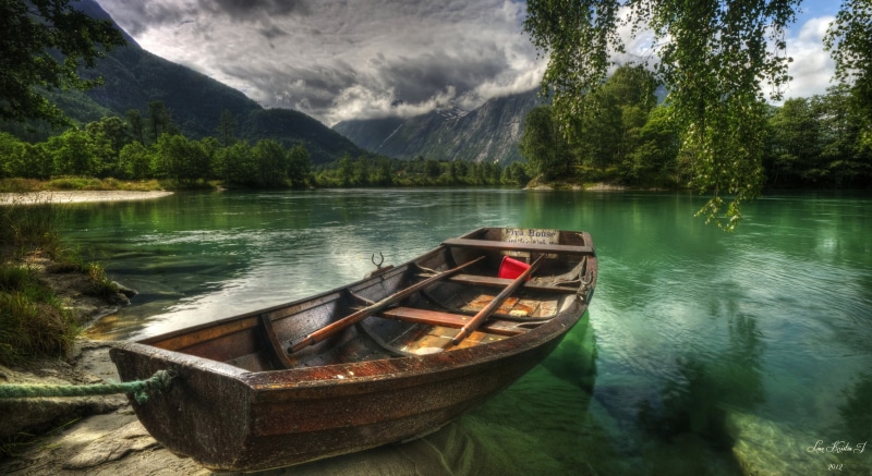 reflection, tree, mode of transportation, lake, nature, sky, black, rowboat, outdoors, beauty in nature, river, tranquility, mountain range, non-urban scene