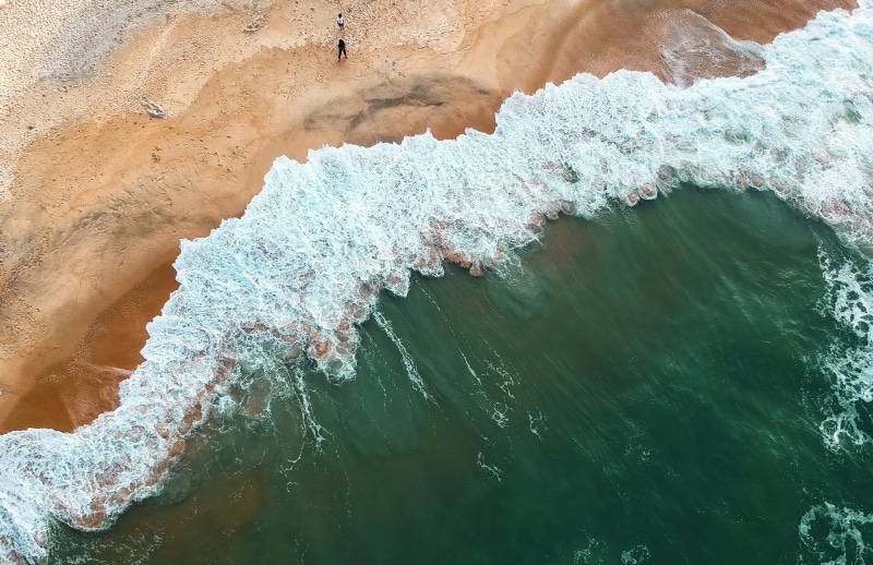 nature, tranquility, rock formation, birds eye view, seawaves, non-urban scene, aquatic sport, waterfront, beauty in nature, sands, high angle view