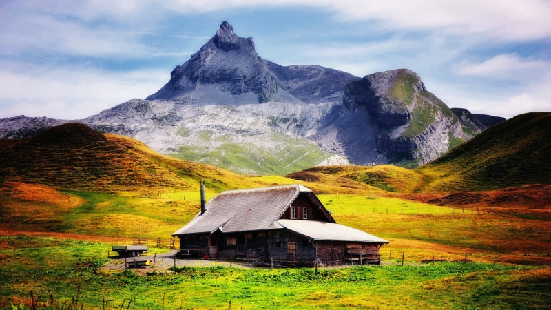 water, travel, building exterior, hut, vacation, land, rock, mountain range, architecture, built structure, mountain peak, horizon, outdoor, mountains
