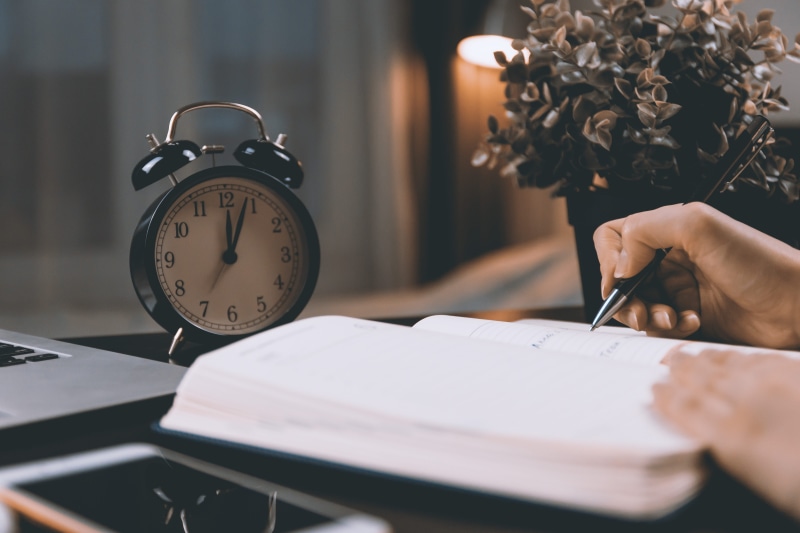 5K, human hand, lifestyles, desk, hand, one person, holding, publication, human body part, clock, clock face, adult, selective focus, midnight, time, book