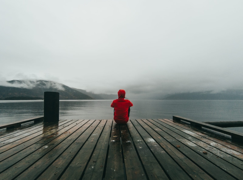 sky, person, sitting, wooden, jacket, red, lifestyles, scenics - nature, looking, wearing, non-urban scene, body, one person, day, wood - material, beauty in nature