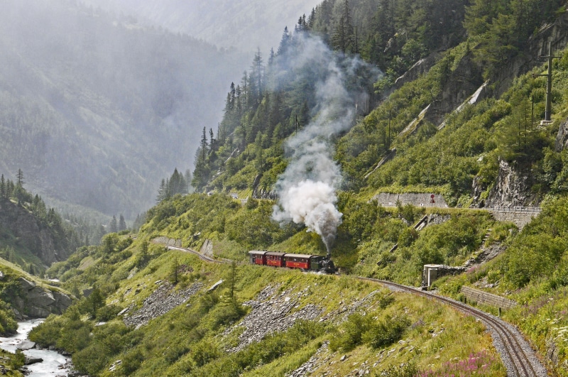 land, no people, forest, beauty in nature, train - vehicle, passing, glacier water, furka, panorama, smoke - physical structure, photo, covered, motion