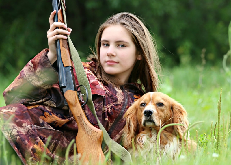 girls, daytime, mammal, rifle, white, teenager, spaniel, portrait, pets, tree, orange, hunter, canine, lies, grass, long hair, beside, women, dog, one animal