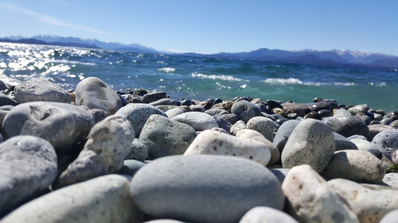 no people, stone - object, tranquility, tranquil scene, water, lake, rocks, outdoors, land, surface level, mountains, beauty in nature, nature, sky, waves