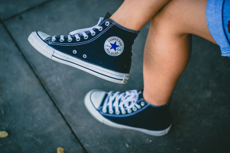 city, casual clothing, black shoes, wearing, sneaks, canvas shoe, chuck taylor, human body part, lifestyles, human leg, skateboard, leisure activity, person