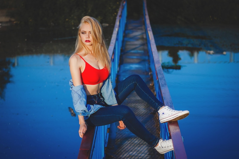front view, focus on foreground, Yana Rzheusskaya, necklace, red lipstick, one person, women outdoors, shirt, pants, three quarter length, casual clothing