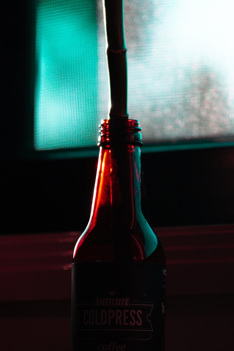 indoors, alcohol, focus on foreground, food and drink, bottle, two objects, red, container, coffee, straw, neon, Cold Press Coffee, no people, close-up