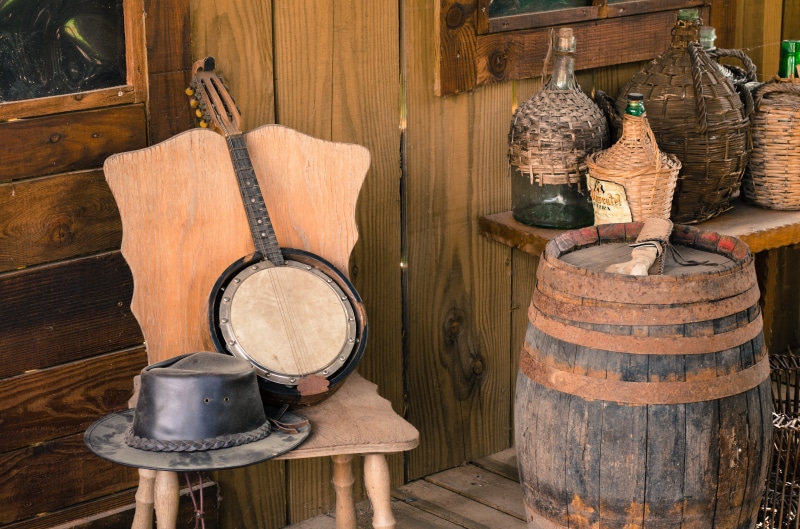 wood - material, wine cask, cylinder, country, wild, field, western, chair, prairie, cellar, wild west, hat, musical instrument, barrel, indoors, scene