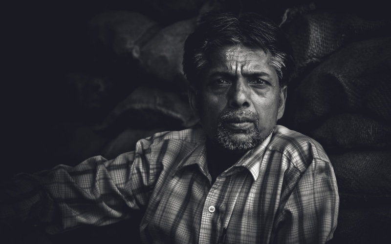 smile, expression, looking at camera, lifestyles, single, black, black background, dress, serious, headshot, contemplation, 4K, real people, beard, human