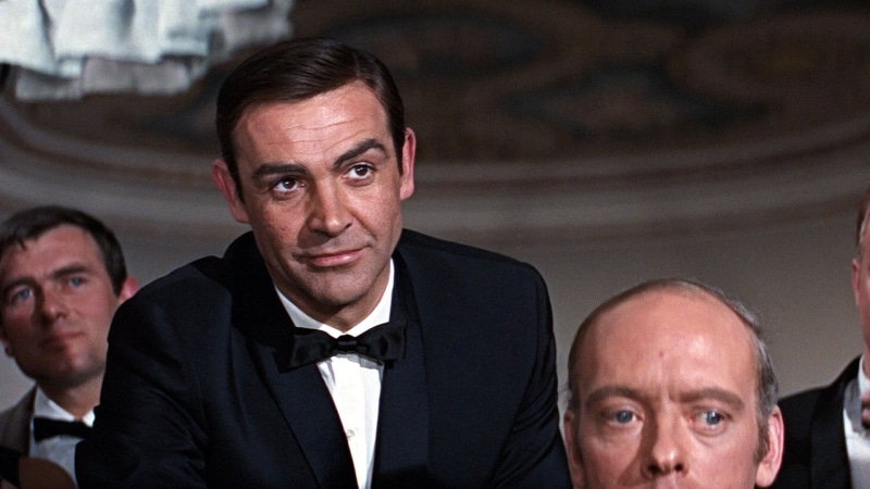 looking at camera, bow tie, formalwear, mature men, movie scenes, indoors, shirt, people, luxury, black, smiling, suit, serious, 1080P, polo, tuxedo, mature adult