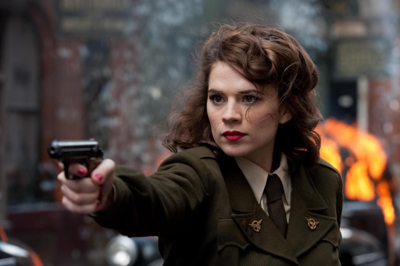 looking at camera, standing, holding, portrait, women, city, hairstyle, actress, The First Avenger, adult, 1080P, well-dressed, clothing, form, gun, Hayley Atwell