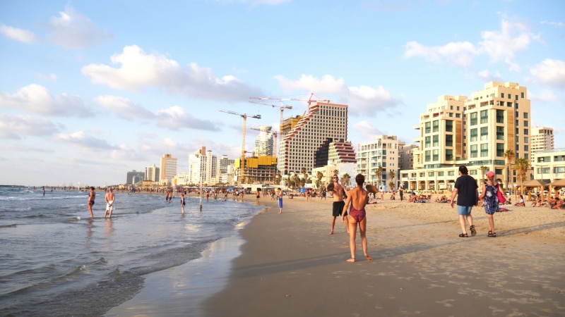 city, 4K, lifestyles, beach, building exterior, real people, office building exterior, group of people, women, architecture, land, water, cityscape, leisure activity