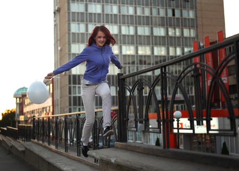 city life, smiling, full length, jump, good mood, joy, ball, mood, day, outdoors, women, russia, positive, railing, architecture, bridge - man made structure