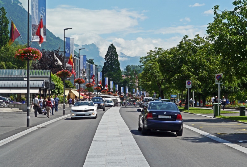 traffic, motor vehicle, park, auto, tree, center, nature, day, interlaken, city, city street, shops, car, cloud - sky, architecture, built structure, switzerland