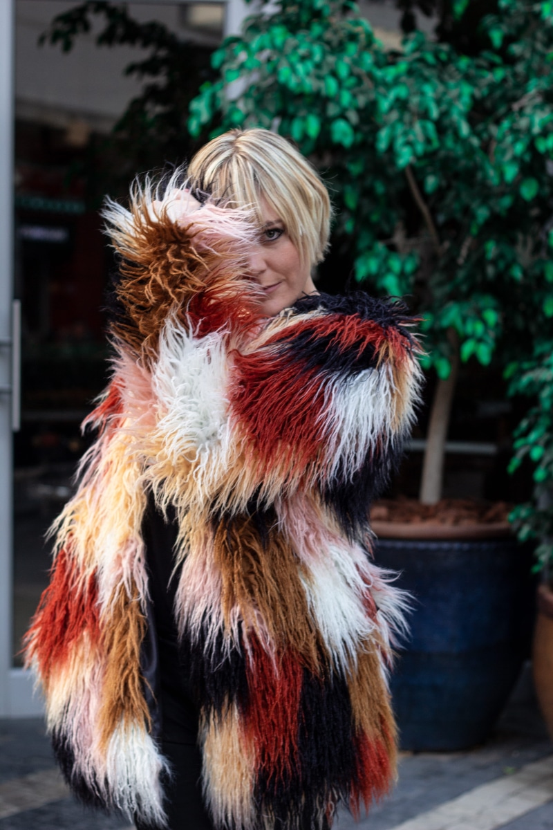 fashion, front view, person, blond hair, costume, black, wearing, smiling, fur coat, 5K, model, adult, beautiful, one person, coat, women, day, clothing